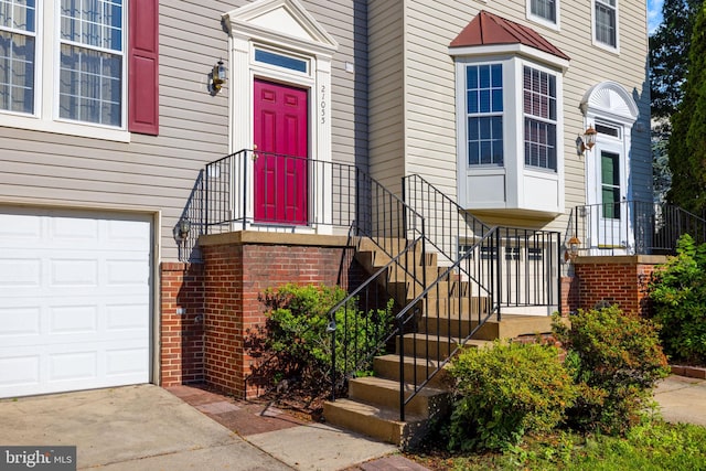 21055 Cornerpost Sq, Ashburn, VA 20147 - property entrance featuring an attached garage and concrete driveway