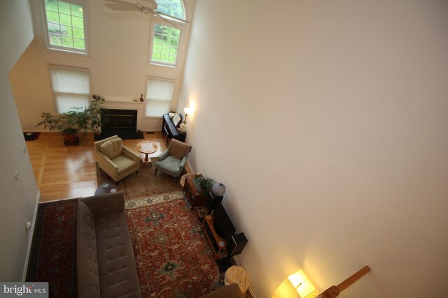 319 Fieldstone Dr, New Hope, PA 18938 - living area with a glass covered fireplace, wood finished floors, a towering ceiling, and a ceiling fan