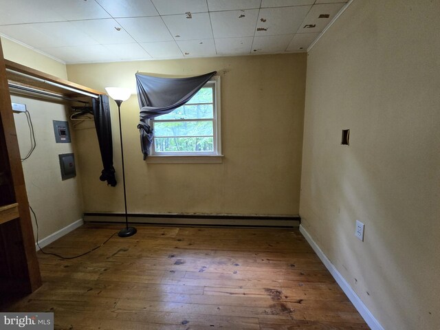 305 Raccoon Dr, Winchester, VA 22602 - unfurnished bedroom with wood-type flooring, a baseboard heating unit, baseboards, and electric panel