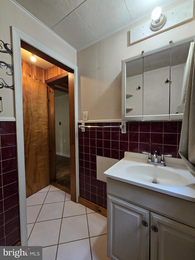 305 Raccoon Dr, Winchester, VA 22602 - bathroom featuring tile walls, tile patterned floors, vanity, crown molding, and a wainscoted wall