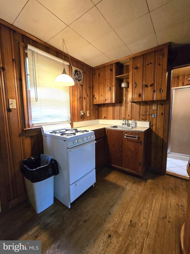305 Raccoon Dr, Winchester, VA 22602 - kitchen featuring white range with gas stovetop, a sink, dark wood finished floors, wood walls, and open shelves