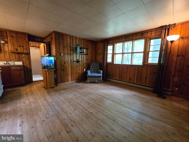 305 Raccoon Dr, Winchester, VA 22602 - unfurnished room featuring a baseboard heating unit, wooden walls, wood-type flooring, a sink, and baseboards