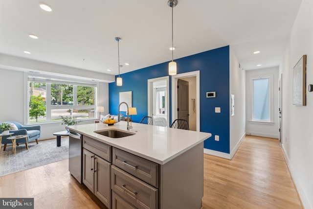 1007 Bryant St NE Unit 3, Washington, DC 20018 - kitchen featuring a sink, dishwasher, light wood-style flooring, decorative light fixtures, and light countertops