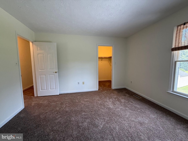 8 Steve Way, Baltimore, MD 21236 - unfurnished bedroom with carpet flooring, a walk in closet, baseboards, a textured ceiling, and a closet