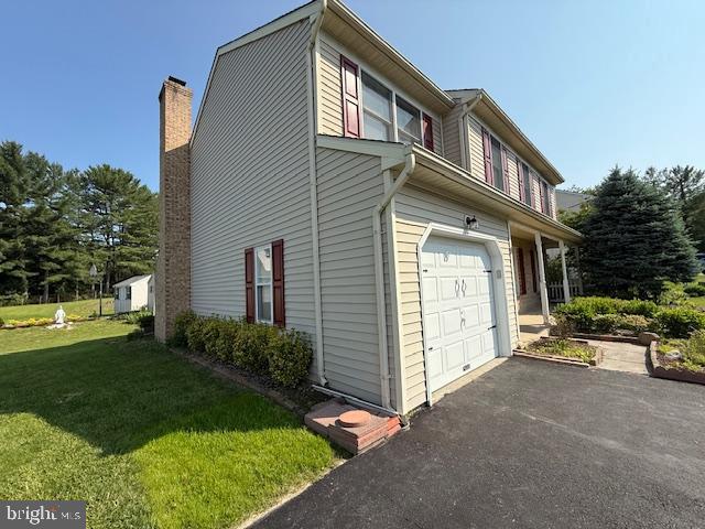 8 Steve Way, Baltimore, MD 21236 - view of side of property featuring a garage, a lawn, driveway, and a chimney