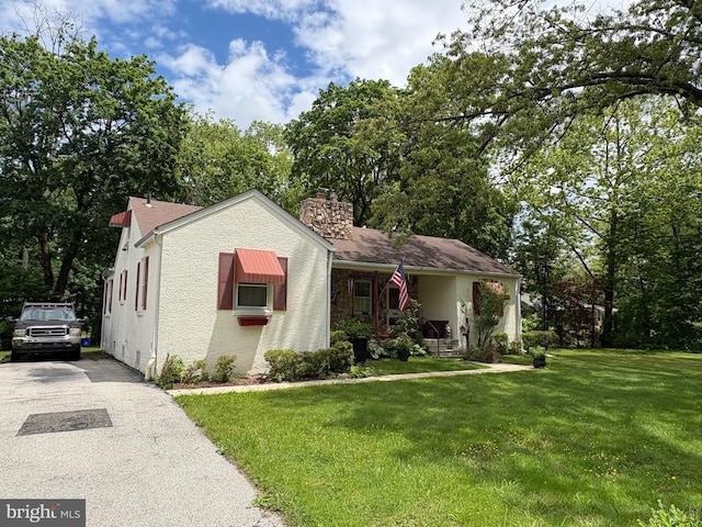 812 Agnes Ave, Morton, PA 19070 - view of front facade with a chimney, a front lawn, stucco siding, and driveway