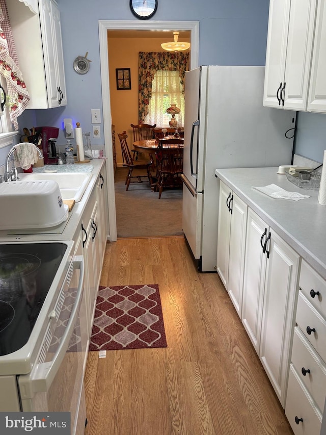 812 Agnes Ave, Morton, PA 19070 - kitchen with a sink, light wood-type flooring, white cabinetry, white appliances, and light countertops