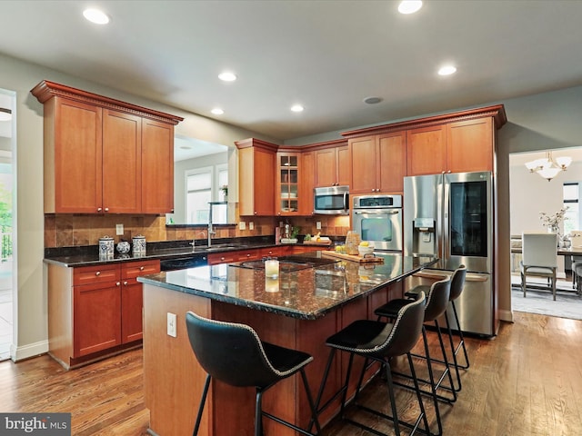 40 Inaugural Way, Charles Town, WV 25414 - kitchen featuring appliances with stainless steel finishes, a kitchen island, wood finished floors, a kitchen breakfast bar, and decorative backsplash