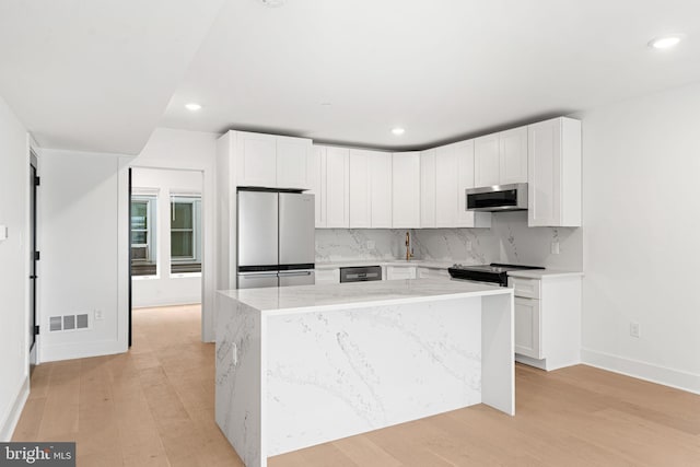 2322 E Cabot St, Philadelphia, PA 19125 - kitchen featuring appliances with stainless steel finishes, decorative backsplash, a center island, light stone counters, and white cabinets