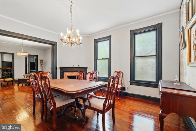 706 Locust St, Cambridge, MD 21613 - dining room with a chandelier, dark wood-type flooring, crown molding, and baseboards