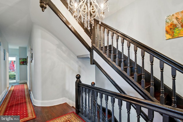 706 Locust St, Cambridge, MD 21613 - stairway with a chandelier, wood finished floors, and baseboards