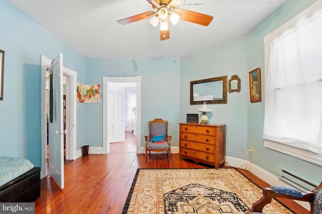 706 Locust St, Cambridge, MD 21613 - living area with baseboard heating, wood-type flooring, a ceiling fan, and baseboards
