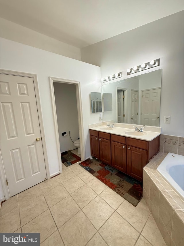 7636 Tall Pin Oak Dr Unit 111, Elkridge, MD 21075 - bathroom featuring a bath, double vanity, tile patterned flooring, and toilet