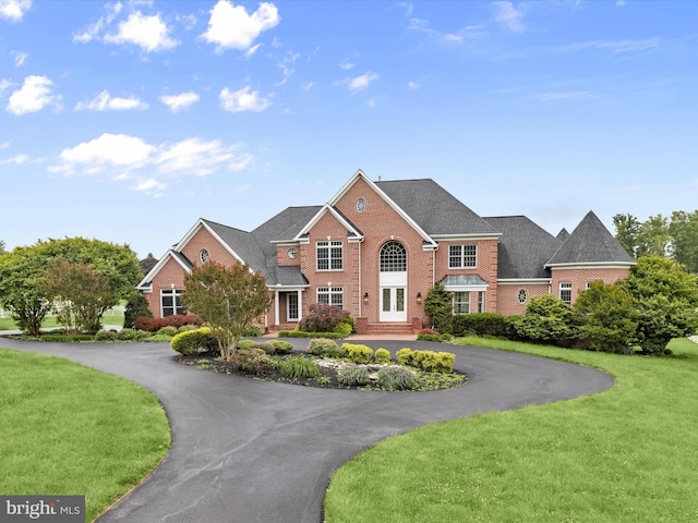 6419 Homebuilder Dr, Mount Airy, MD 21771 - georgian-style home with curved driveway, a front yard, brick siding, and french doors
