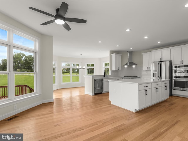 6419 Homebuilder Dr, Mount Airy, MD 21771 - kitchen with wall chimney exhaust hood, light countertops, healthy amount of natural light, light wood finished floors, and recessed lighting
