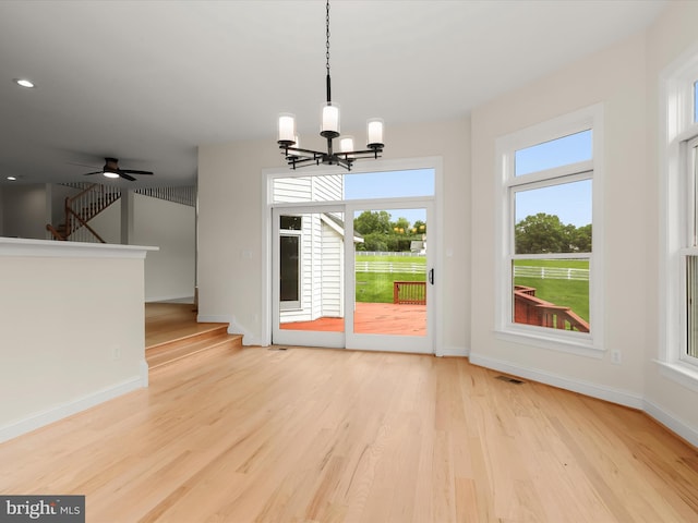 6419 Homebuilder Dr, Mount Airy, MD 21771 - unfurnished dining area featuring a chandelier, light wood-style flooring, baseboards, ceiling fan, and stairway