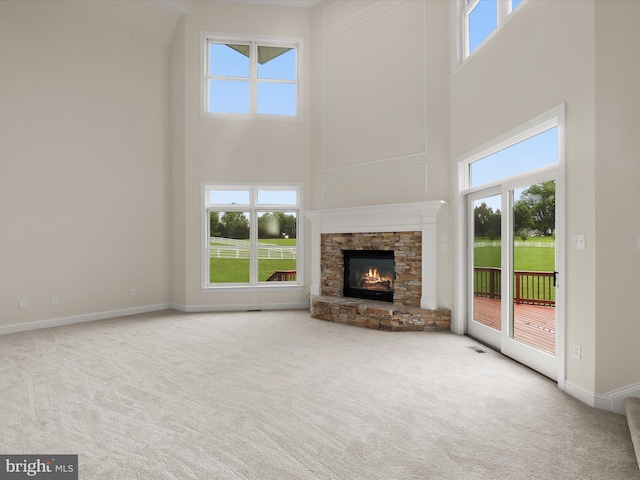 6419 Homebuilder Dr, Mount Airy, MD 21771 - unfurnished living room with a towering ceiling, carpet, plenty of natural light, a stone fireplace, and baseboards