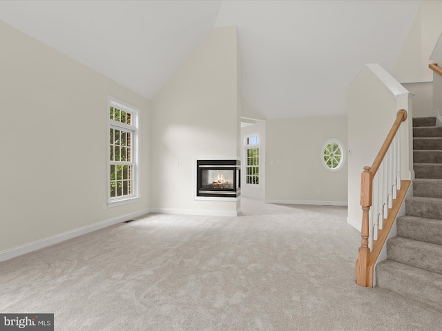 6419 Homebuilder Dr, Mount Airy, MD 21771 - unfurnished living room with high vaulted ceiling, stairway, carpet floors, a multi sided fireplace, and baseboards