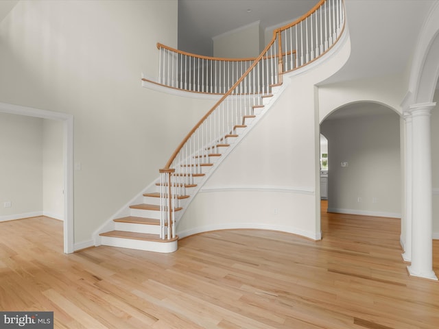6419 Homebuilder Dr, Mount Airy, MD 21771 - stairway featuring decorative columns, arched walkways, a high ceiling, wood finished floors, and baseboards