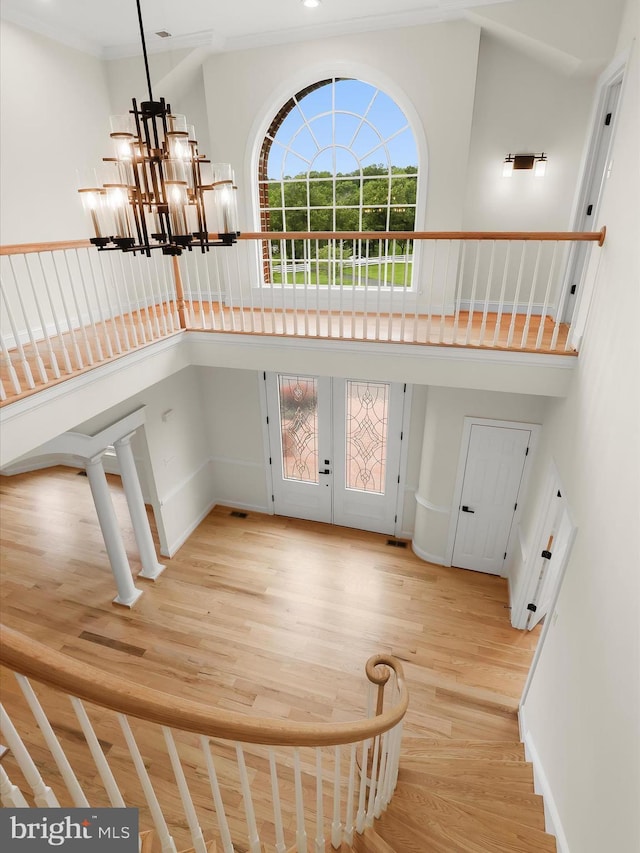 6419 Homebuilder Dr, Mount Airy, MD 21771 - staircase featuring wood finished floors, a high ceiling, french doors, a chandelier, and baseboards