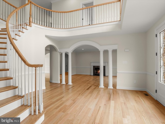6419 Homebuilder Dr, Mount Airy, MD 21771 - foyer with a warm lit fireplace, stairs, wood finished floors, ornate columns, and baseboards