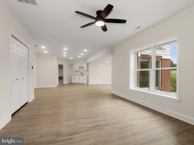 6419 Homebuilder Dr, Mount Airy, MD 21771 - unfurnished living room with light wood-style floors, baseboards, a ceiling fan, recessed lighting, and a sink
