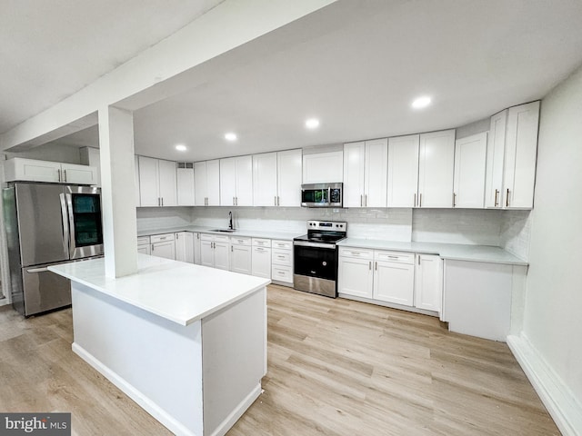 23 Karen Ct, New Castle, DE 19720 - kitchen with stainless steel appliances, a sink, light wood finished floors, white cabinets, and recessed lighting
