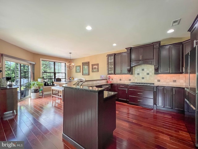 414 Saint James Ct, Langhorne, PA 19047 - kitchen with dark wood-type flooring, a chandelier, stainless steel gas cooktop, dark stone countertops, and tasteful backsplash