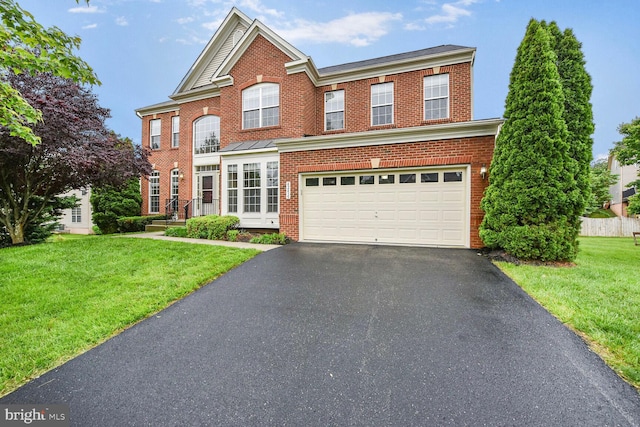 42435 Ibex Dr, Sterling, VA 20166 - view of front of home with brick siding, asphalt driveway, a front lawn, and an attached garage