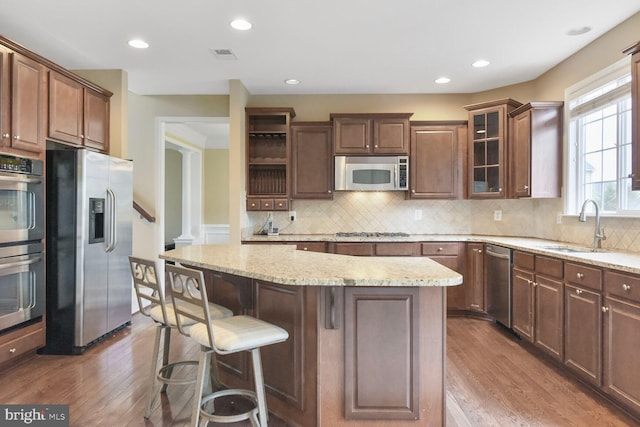 42435 Ibex Dr, Sterling, VA 20166 - kitchen with stainless steel appliances, dark wood-style floors, a kitchen breakfast bar, a center island, and recessed lighting
