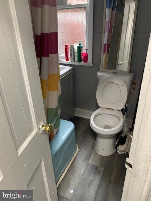 1716 Miller St, Harrisburg, PA 17103 - bathroom featuring toilet, wood finished floors, baseboards, washer / clothes dryer, and a shower with curtain