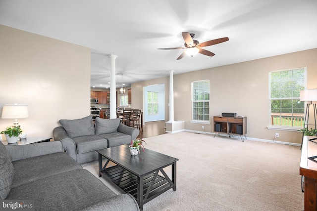 5194 Longbow Rd, King George, VA 22485 - living area with ornate columns, a ceiling fan, light colored carpet, and plenty of natural light