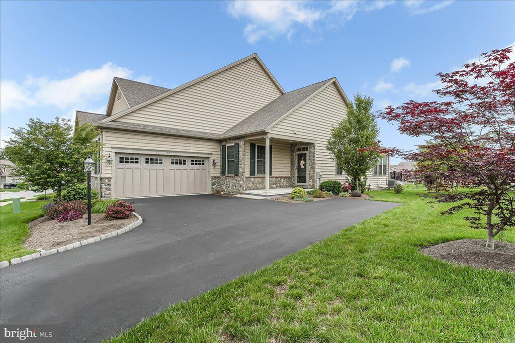 217 Honeycroft Blvd, Cochranville, PA 19330 - view of front facade featuring stone siding, driveway, a shingled roof, a garage, and a front yard