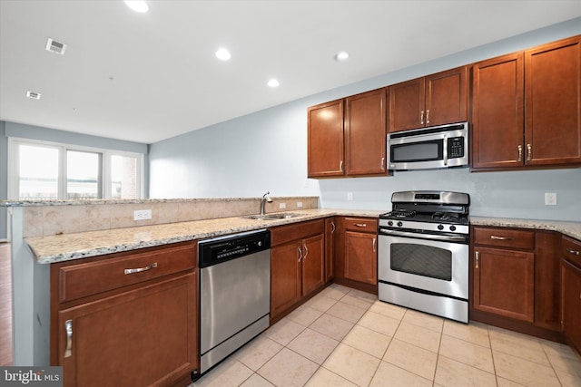 113 E Main St Unit 303, Newark, DE 19711 - kitchen with appliances with stainless steel finishes, a peninsula, light stone countertops, light tile patterned flooring, and recessed lighting