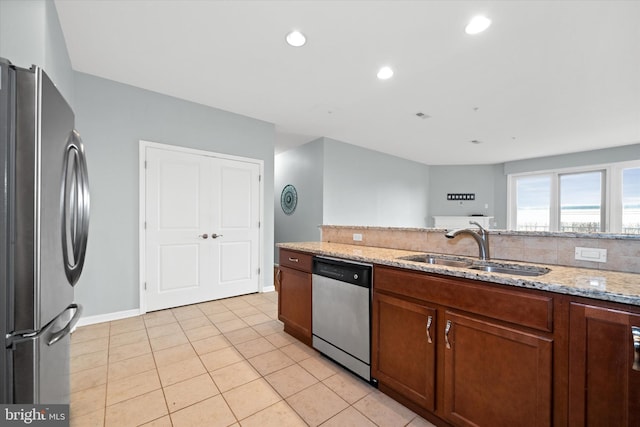 113 E Main St Unit 303, Newark, DE 19711 - kitchen with appliances with stainless steel finishes, light stone countertops, light tile patterned flooring, brown cabinets, and recessed lighting