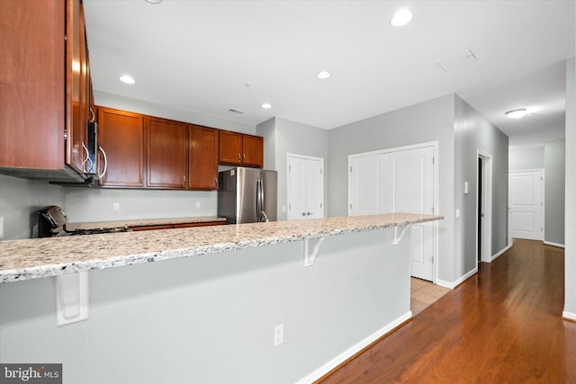 113 E Main St Unit 303, Newark, DE 19711 - kitchen featuring appliances with stainless steel finishes, a peninsula, a kitchen breakfast bar, light stone counters, and recessed lighting