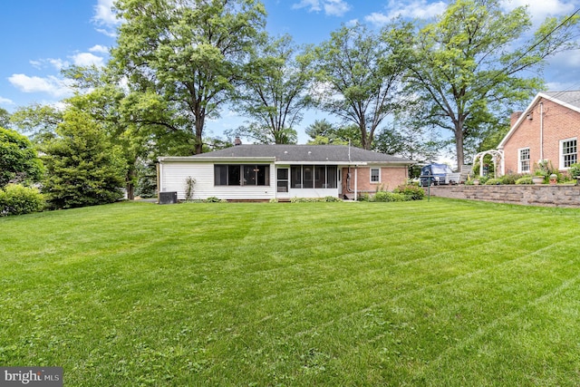 243 Park Ave, Mount Joy, PA 17552 - back of house with a sunroom, a lawn, brick siding, and cooling unit
