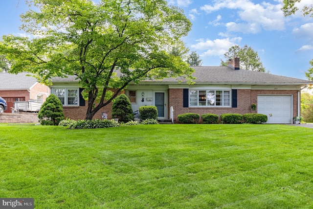 243 Park Ave, Mount Joy, PA 17552 - view of front of house with a garage, brick siding, a chimney, and a front yard
