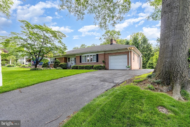 243 Park Ave, Mount Joy, PA 17552 - ranch-style home with an attached garage, asphalt driveway, brick siding, a chimney, and a front yard