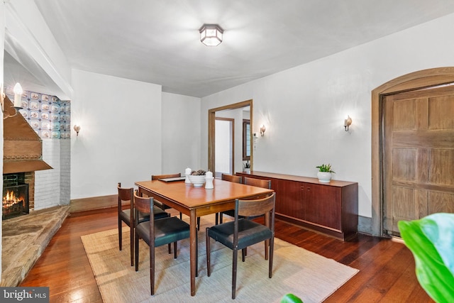 8515 Seminole St, Philadelphia, PA 19118 - dining room featuring dark wood-type flooring, a fireplace, and arched walkways