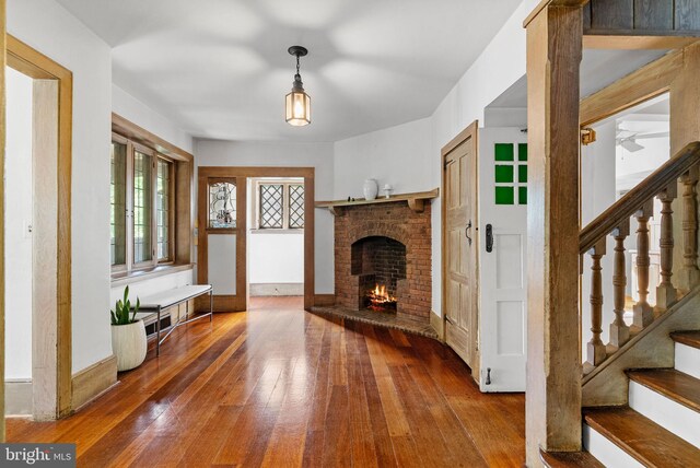 8515 Seminole St, Philadelphia, PA 19118 - unfurnished living room featuring a fireplace, hardwood / wood-style flooring, stairway, and a ceiling fan