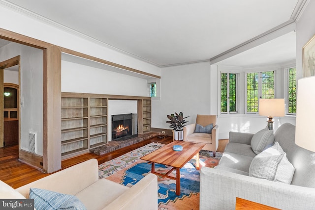8515 Seminole St, Philadelphia, PA 19118 - living area featuring wood finished floors, a brick fireplace, built in shelves, and ornamental molding