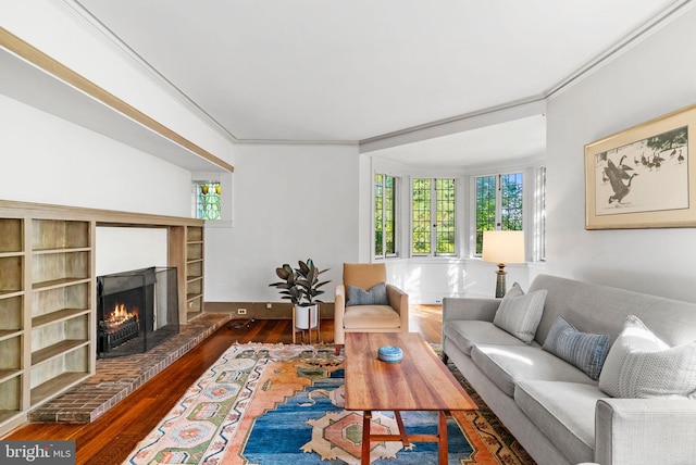 8515 Seminole St, Philadelphia, PA 19118 - living room featuring ornamental molding, healthy amount of natural light, hardwood / wood-style floors, and a brick fireplace