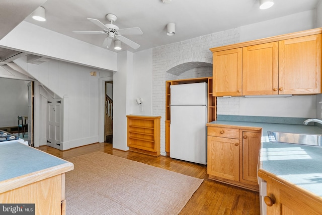 8515 Seminole St, Philadelphia, PA 19118 - kitchen with freestanding refrigerator, a sink, a ceiling fan, wood finished floors, and light countertops