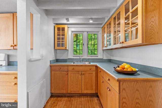 8515 Seminole St, Philadelphia, PA 19118 - kitchen featuring a sink, beamed ceiling, light wood-type flooring, glass insert cabinets, and light countertops
