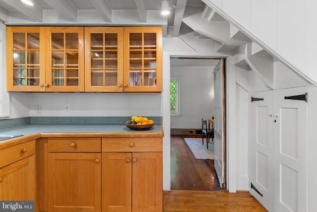 8515 Seminole St, Philadelphia, PA 19118 - kitchen with wood finished floors, beam ceiling, glass insert cabinets, and light countertops