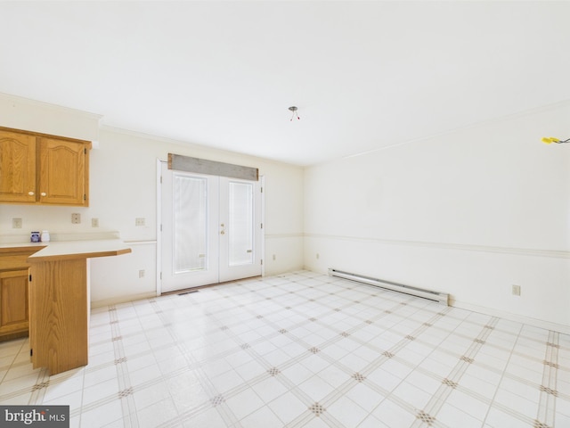 423 W Market St, Georgetown, DE 19947 - kitchen featuring baseboard heating, light countertops, brown cabinets, light flooring, and french doors