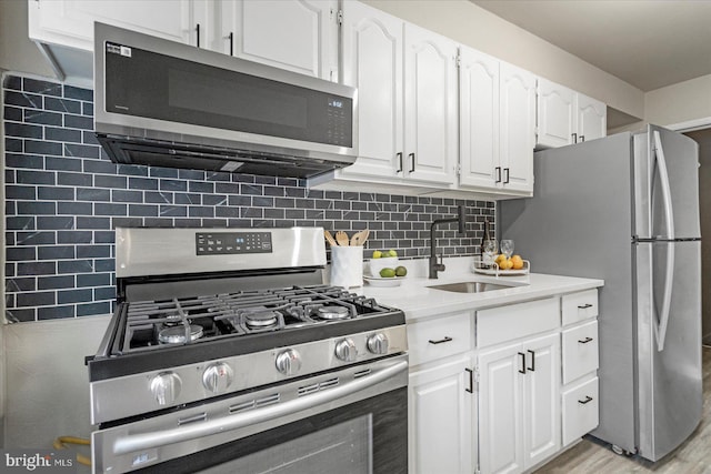 7509 Durwood Rd, Baltimore, MD 21222 - kitchen featuring appliances with stainless steel finishes, a sink, white cabinetry, backsplash, and light countertops
