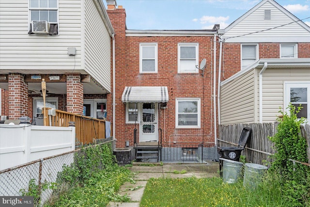 7509 Durwood Rd, Baltimore, MD 21222 - rear view of house featuring entry steps, brick siding, a fenced backyard, and a chimney