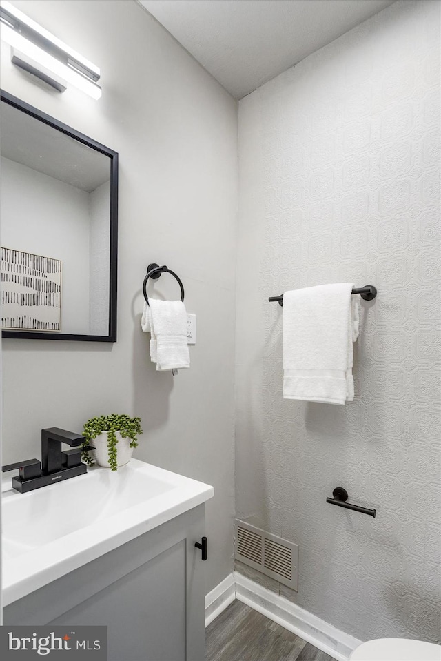 7509 Durwood Rd, Baltimore, MD 21222 - bathroom featuring wood finished floors, baseboards, vanity, and toilet